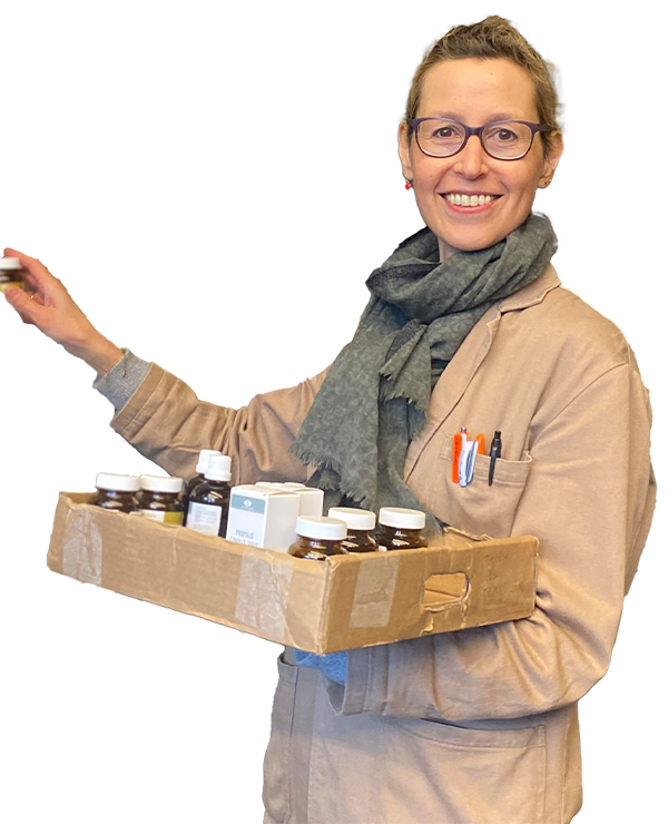 Lachende winkelmedewerker Maud, vrouw met bril en stofjas en tray met producten