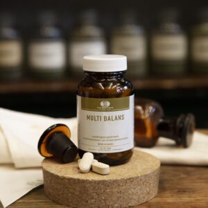 Bruine glazen pot witte deksel Multi balans multivitaminen en mineralen, op houten kurk met decoratie bruin glazen stopfles en witte doek