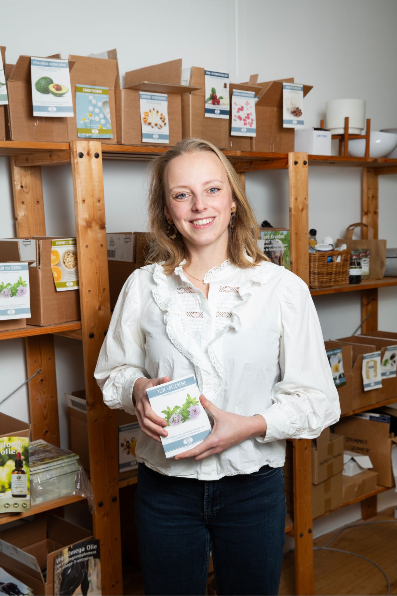 Lachend personeelslid Sophie in het magazijn met een doos in de handen