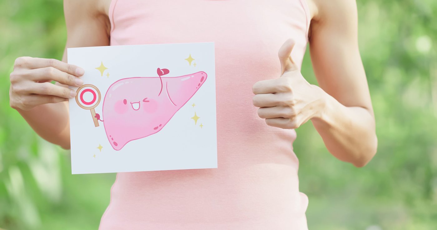 Meisje met roze shirt met een tekening in de hand van een blije roze lever. Meisje duimpje omhoog. groene achtergrond. e-book de lever uitgelegd