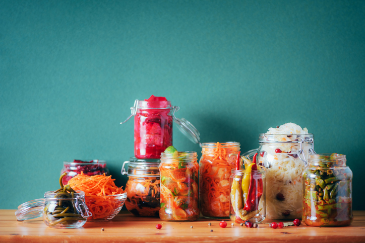 postbiotica uit gefermenteerde voeding Assortiment van verschillende gefermenteerde en gemarineerde gerechten op houten ondergrond, kopieerruimte. Gefermenteerde groenten, zuurkool, peper, knoflook, rode biet, Koreaanse wortel, komkommer-kimchi in glazen potten