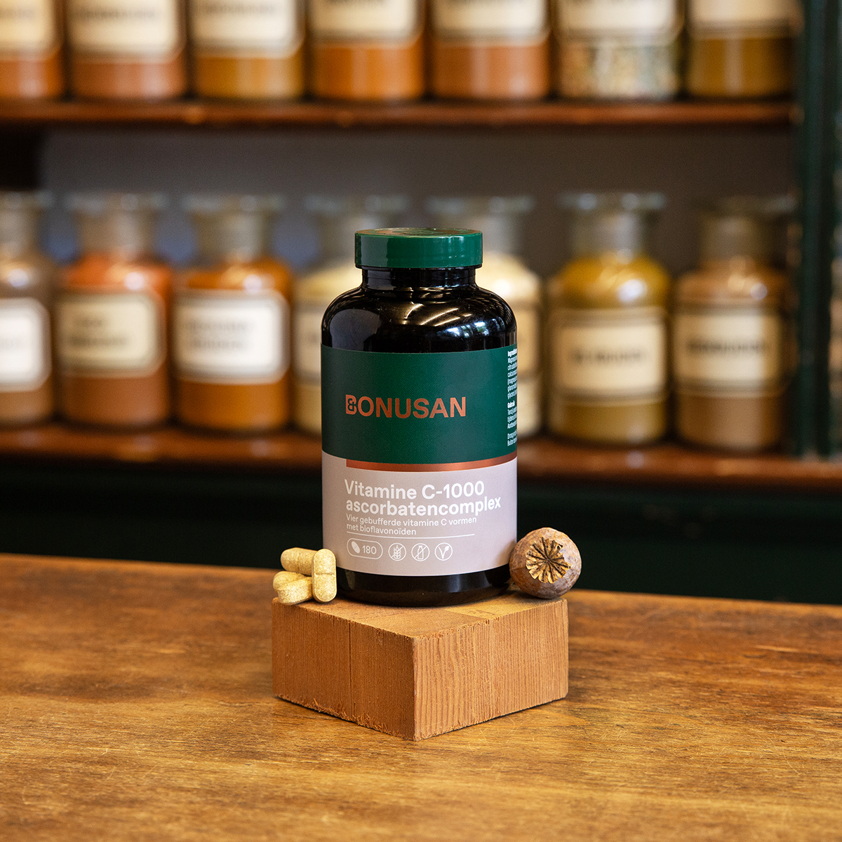 vitamine C ascorbatencomplex groene plastic pot op houten ondergrond
