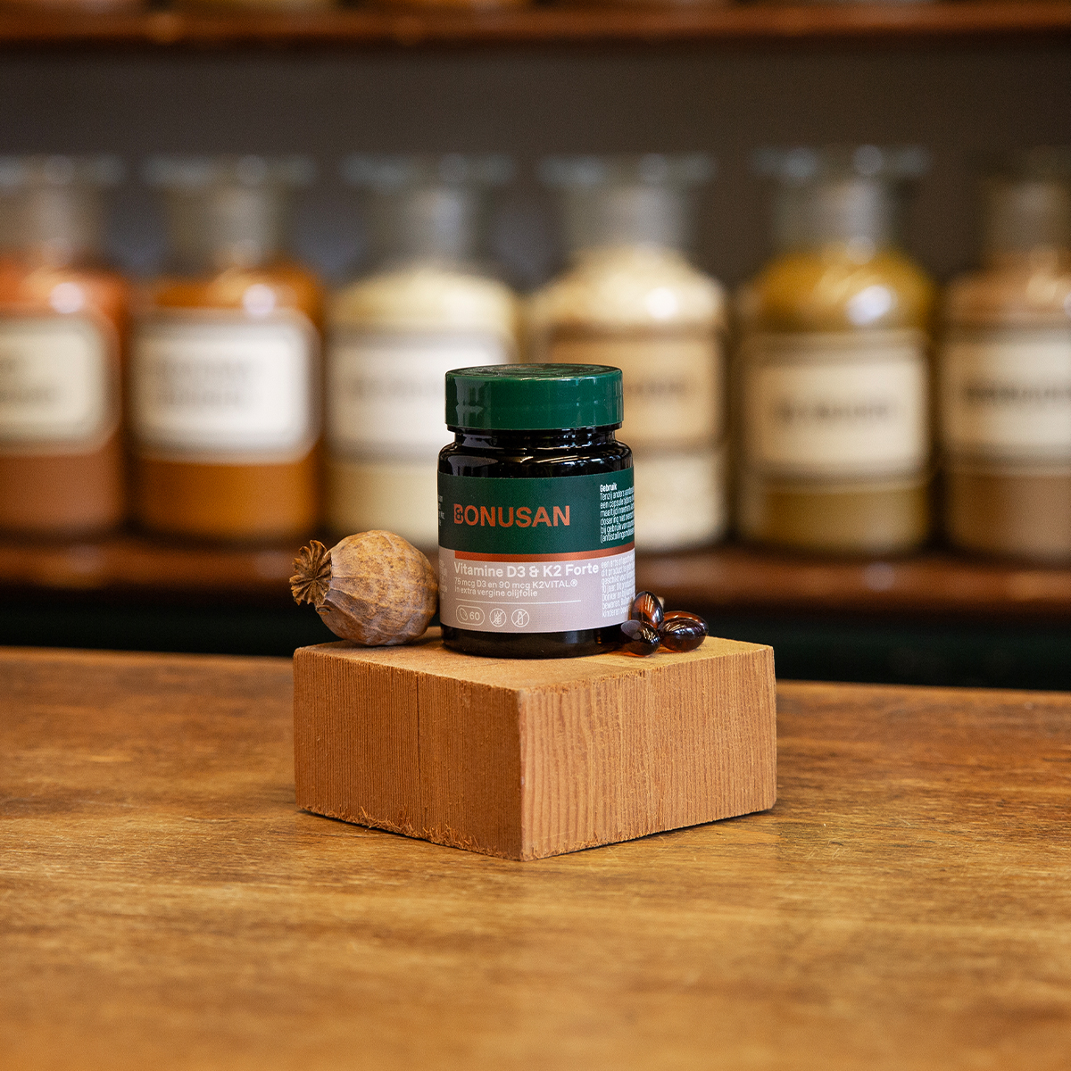 vitamine D3 en K2 groene plastic pot bonusan houten ondergrond