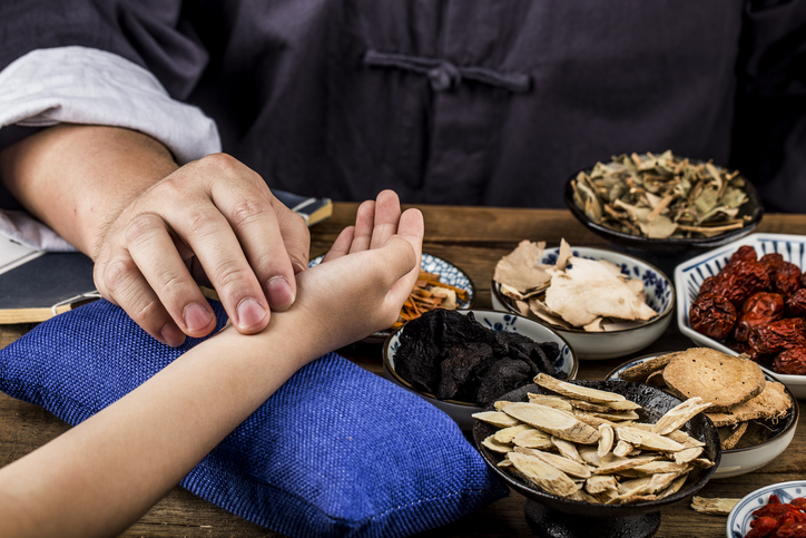 De oude dokter van de traditionele Chinese geneeskunde voelt de pols van de patiënt.